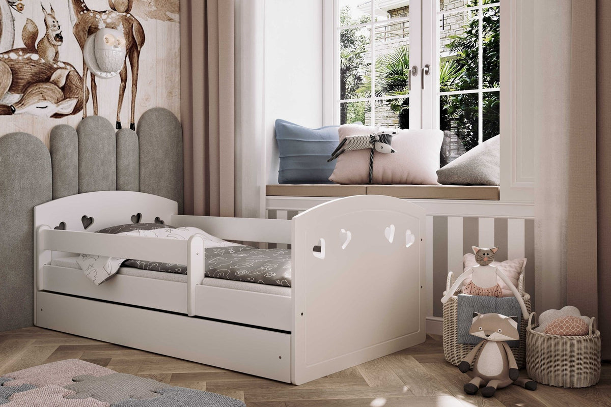 Lit enfant blanc à barrière de sécurité et tiroir, dans une chambre aux tons gris