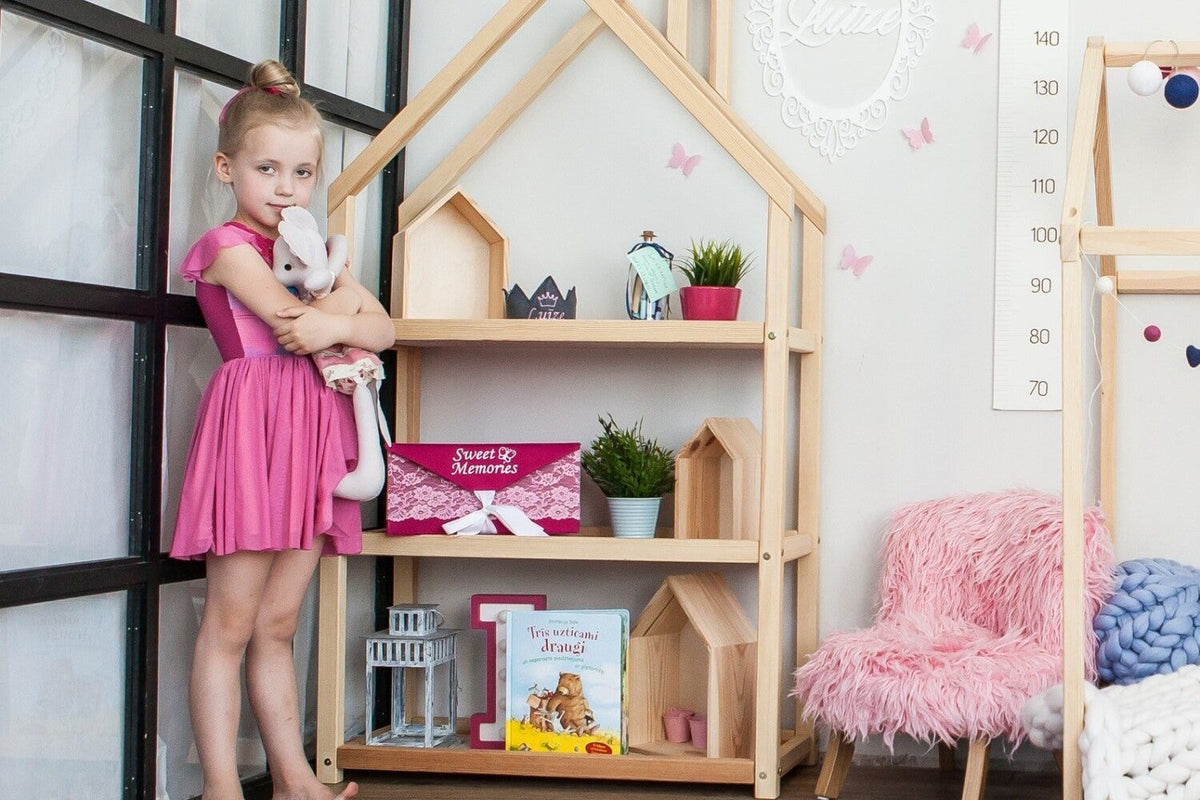 Enfant devant une étagère maison en bois où les jouets sont présentés