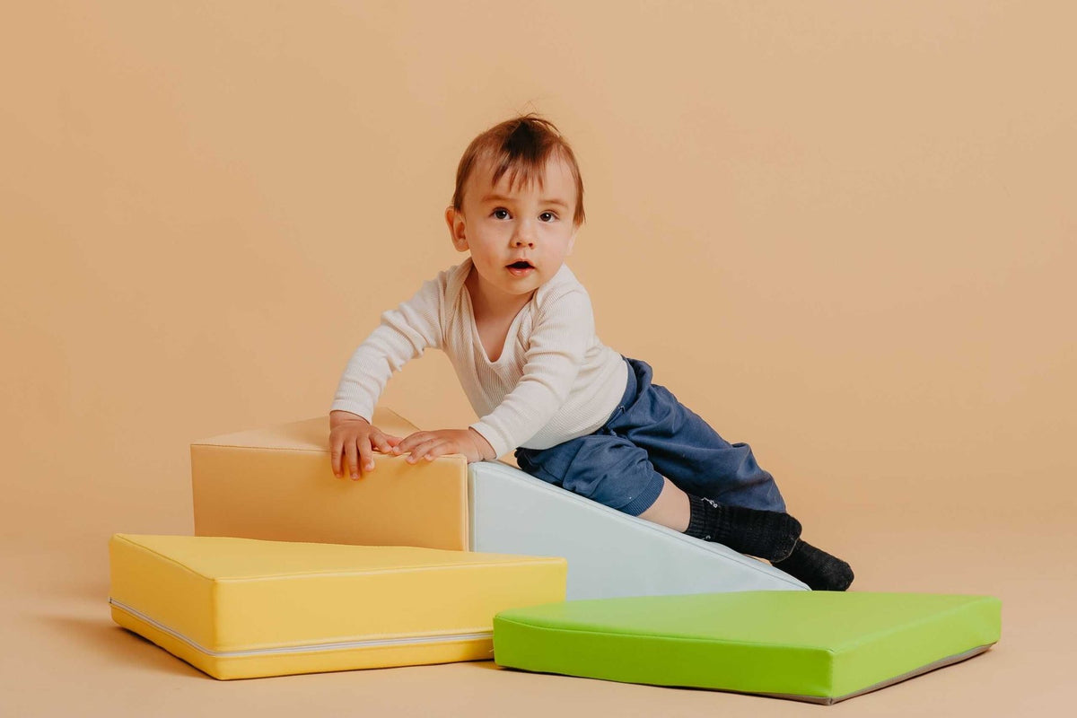 Bébé qui grimpe sur des blocs de motricité en mousse