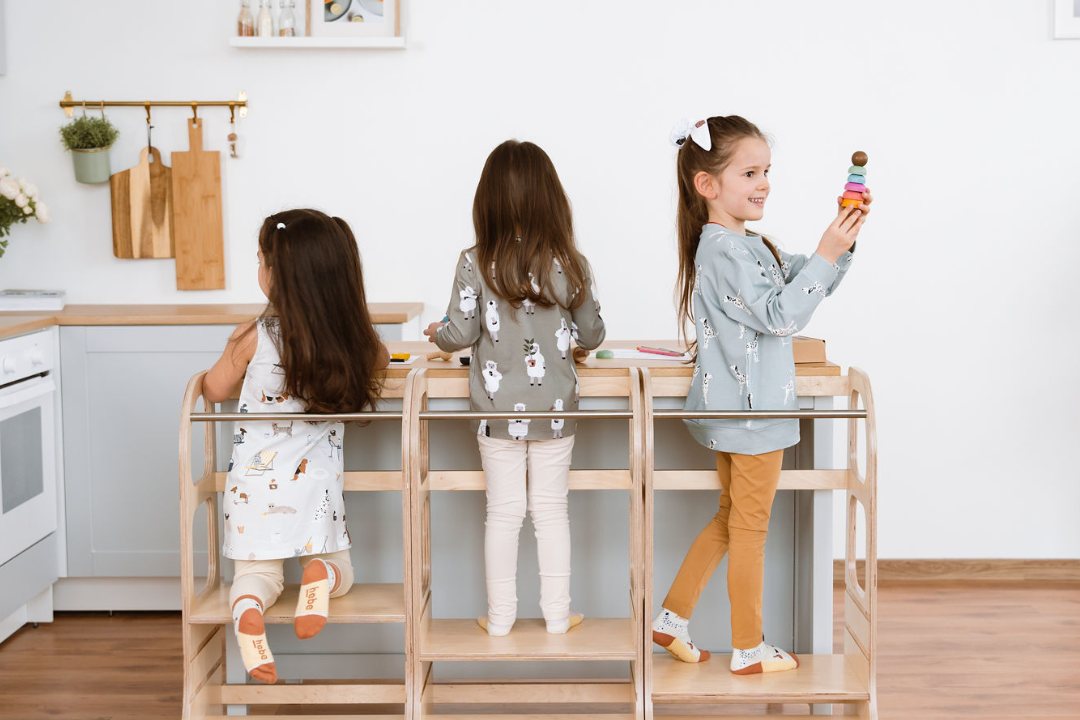 Trois enfants sur des tours d'observation en bois devant le plan de travail