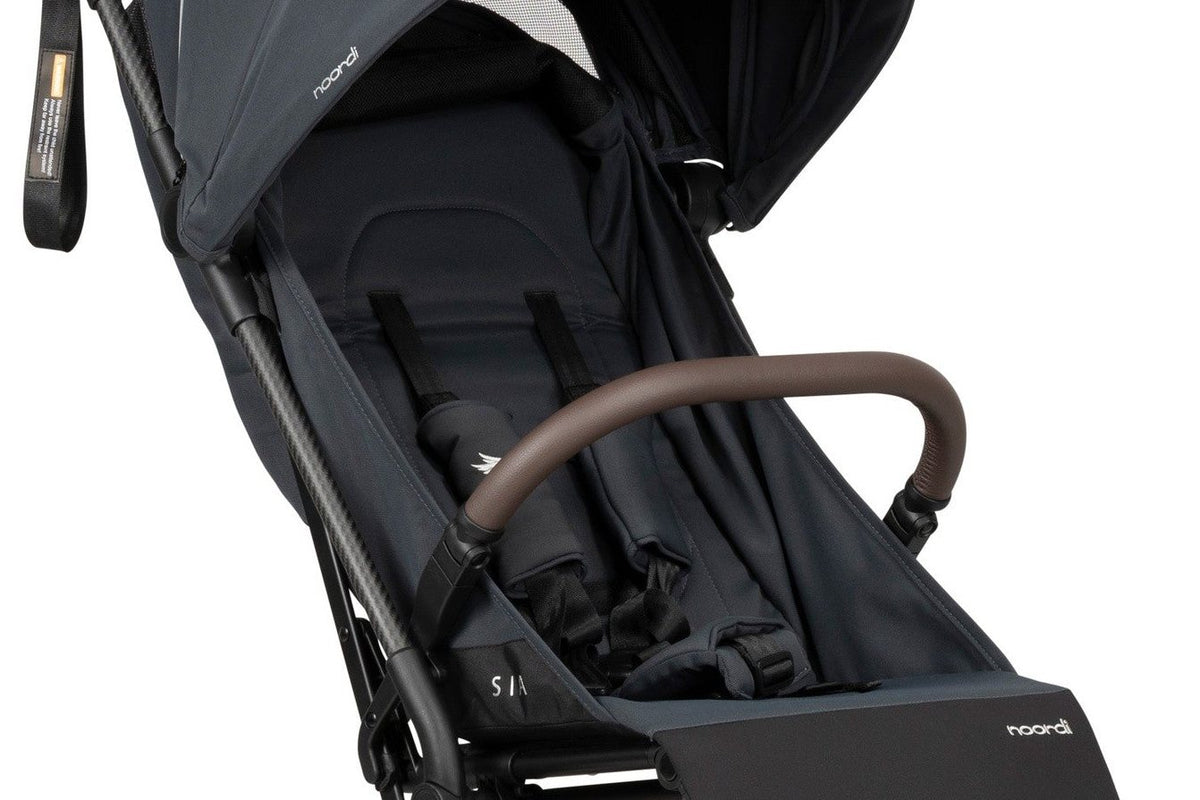 Assise d'une poussette compacte bleu nuit avec harnais et arceau, sur fond blanc