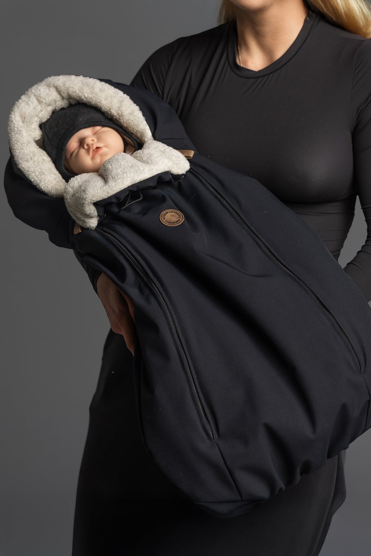Un bébé dans une chancelière Lenne fourrée noire