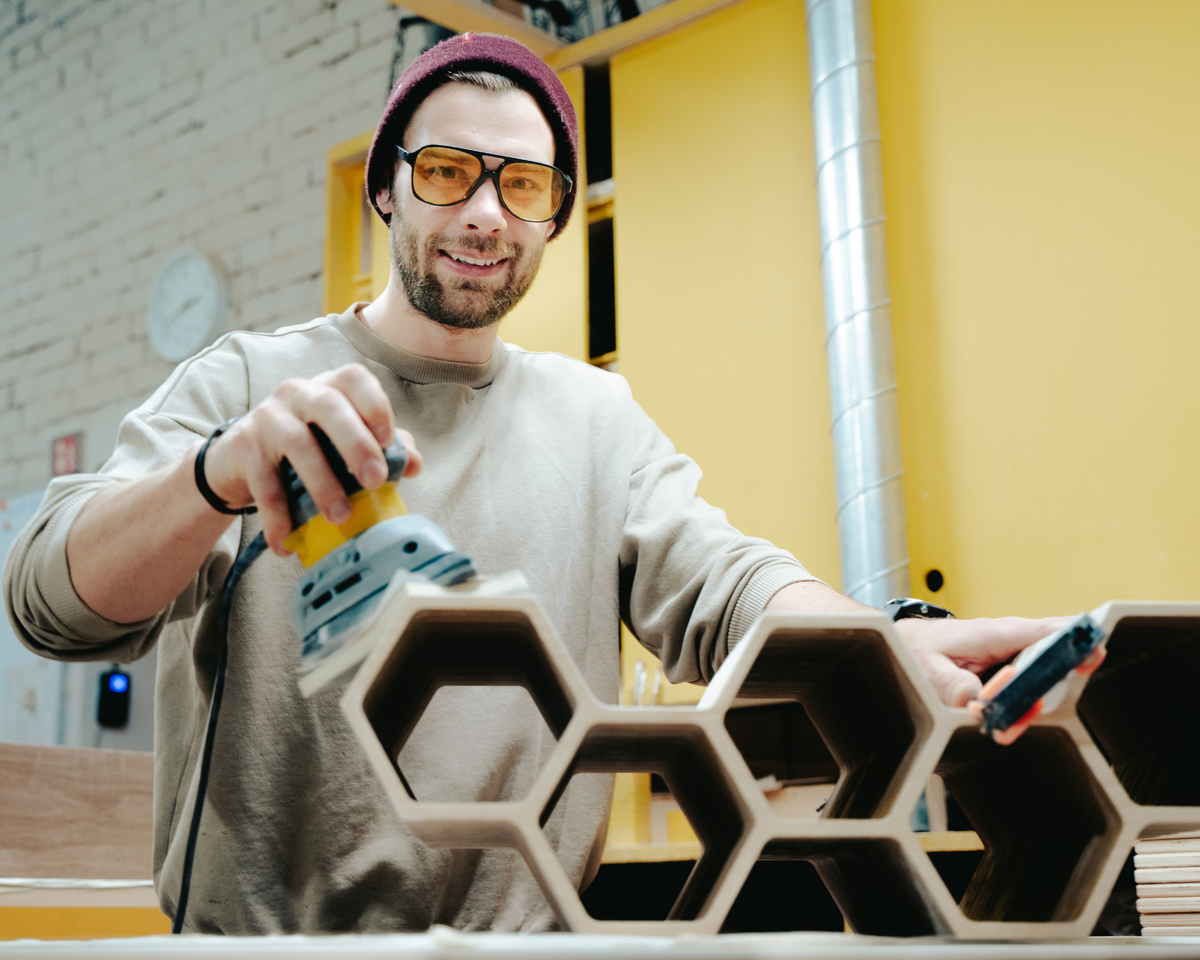 Un artisan d'Ewart Woods travaille sur des étagères hexagonales dans l'atelier