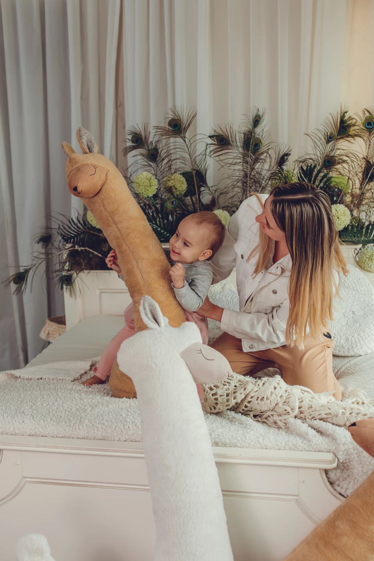 Une maman et son bébé avec des peluches alpaga Kai aš mažas buvau