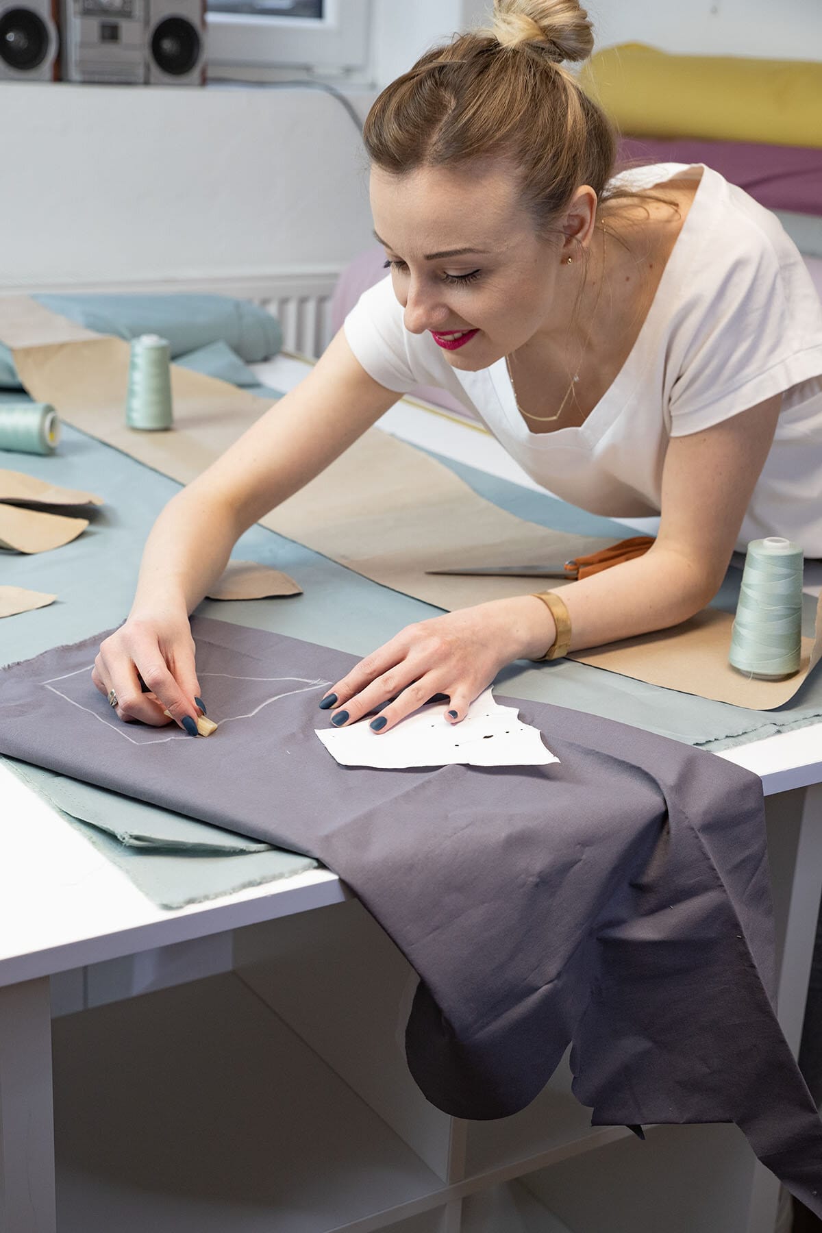 Une couturière de CuddleRest trace un patron sur du tissu dans l'atelier