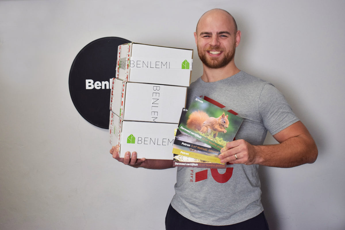 Un cofondateur de Benlemi tient des cartons Benlemi et un certificat de plantation de forêt