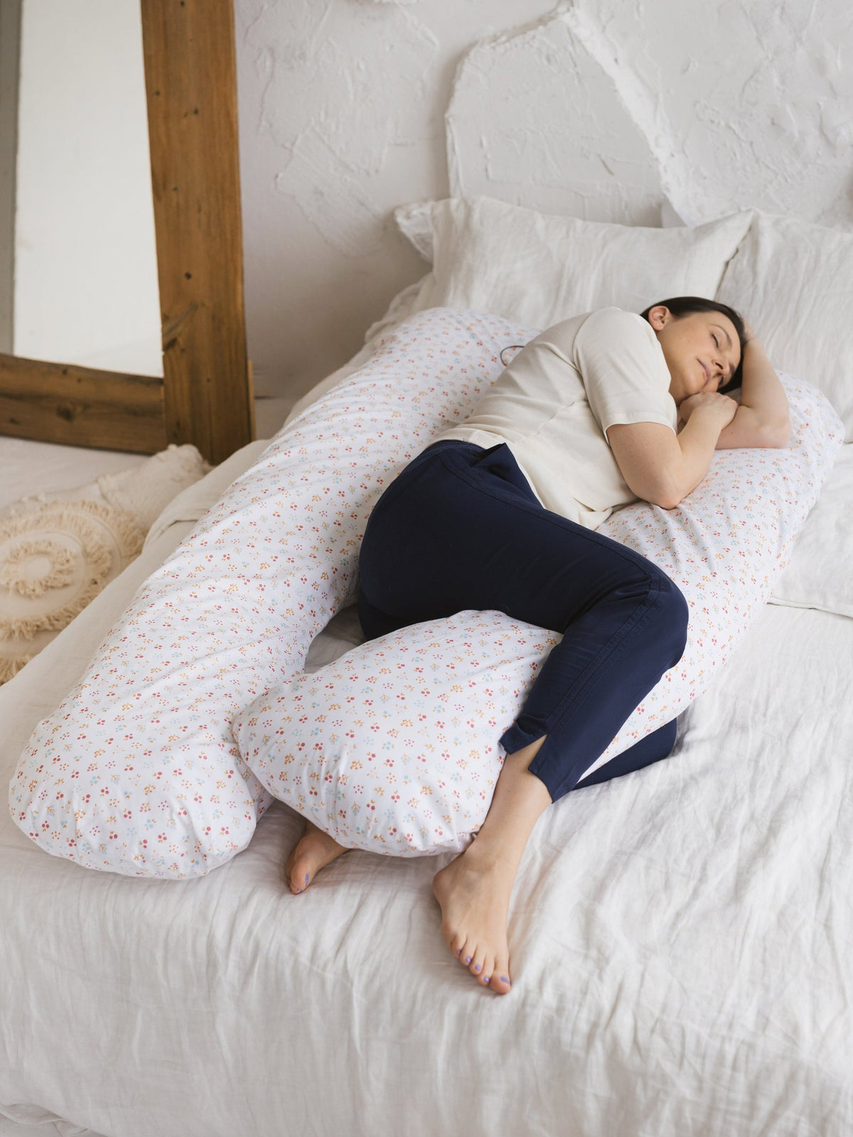 Une femme enceinte se repose sur un coussin de grossesse en U Minicamp