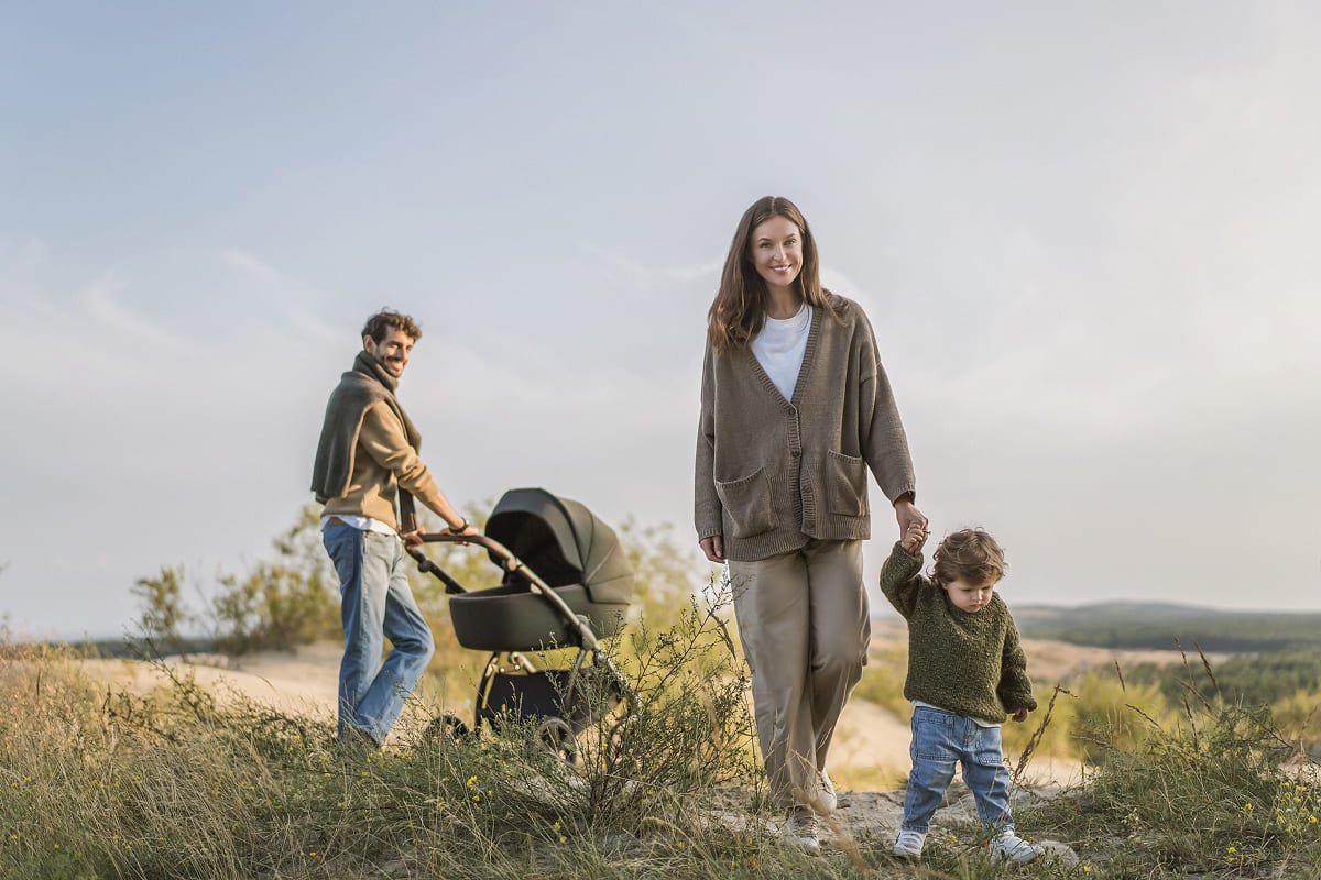 Une famille se promène dans les dunes avec une poussette Noordi